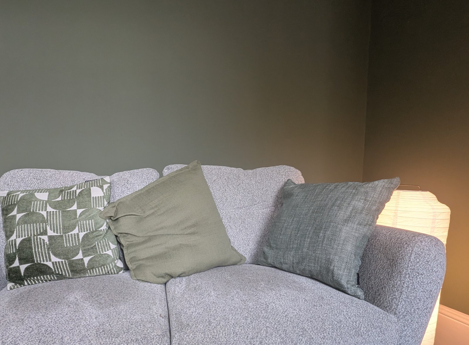 A sofa with cushions and a warm lamp in a therapy room