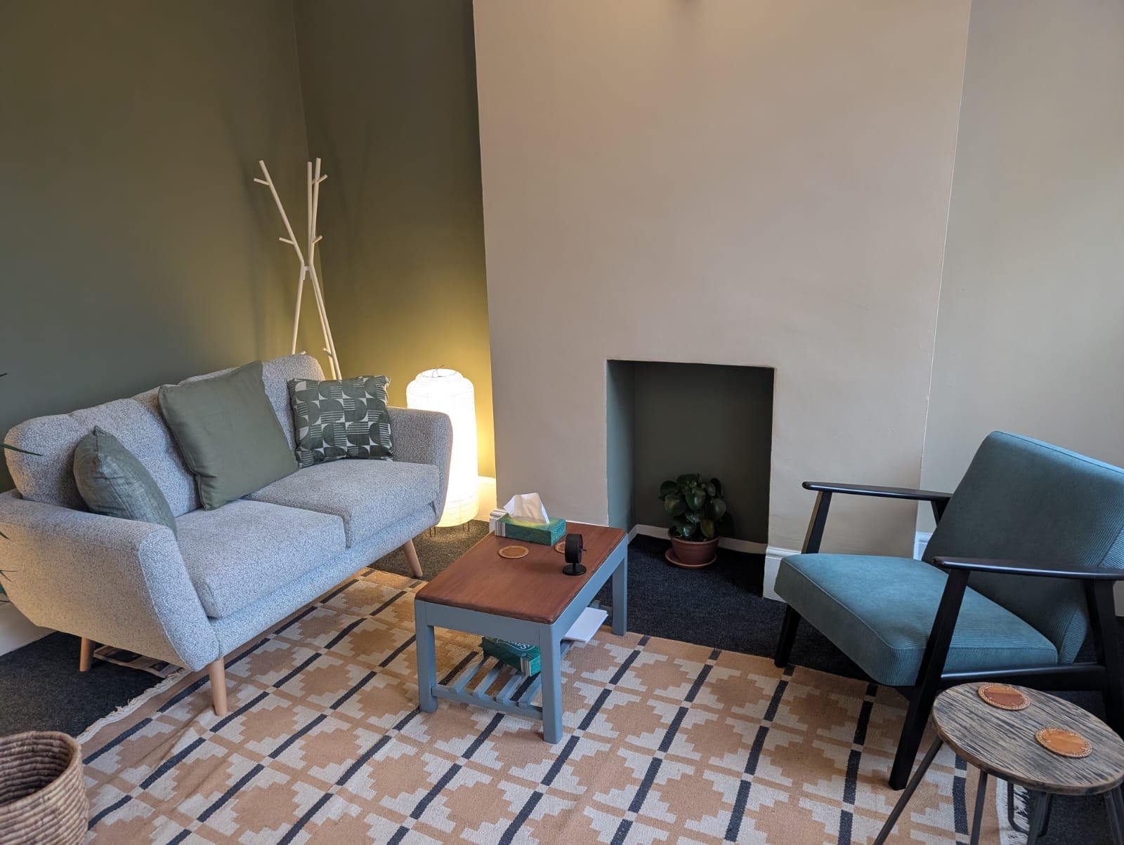 The therapy room in Shoreditch: a sofa and armchair facing each other, with a low table between them.